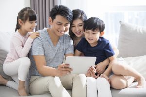 Happy young family using digital tablet at home