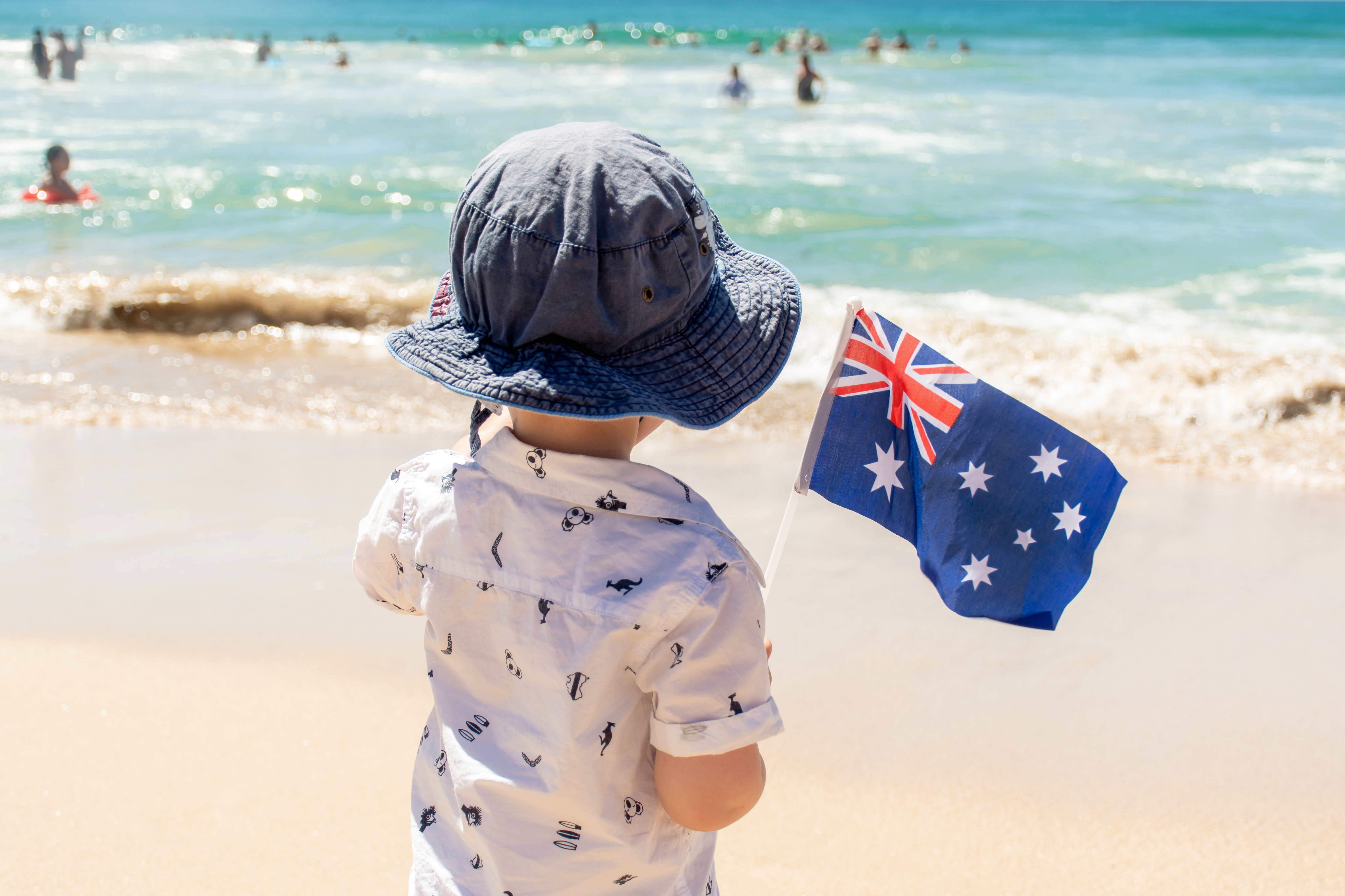 Little boy with Australian flag near the ocean. Australia Day concept