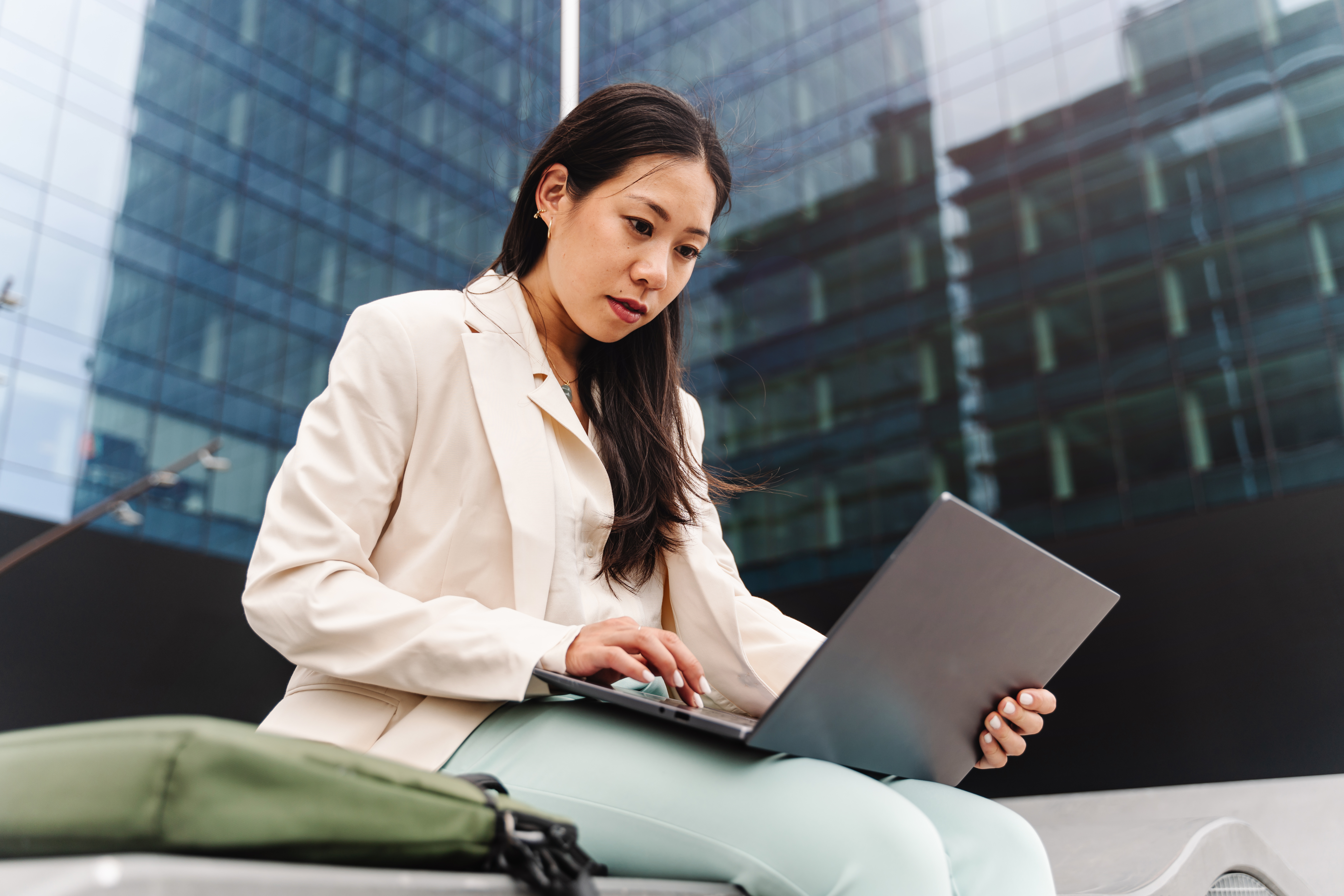 Young Asian Professional Business Woman working on laptop outside the office
